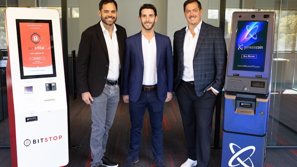 Doug Carrillo (Bitstop), Evan Rose (Genesis Coin), and Andrew Barnard (Bitstop) standing between a Bitstop ATM and a Genesis Coin ATM at the time of the 2023 acquisition