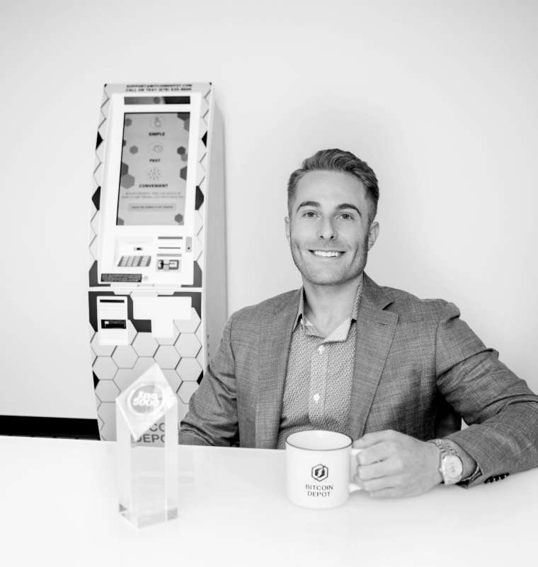 Brandon Mintz, founder of Bitcoin Depot, posing with a Bitcoin Depot ATM kiosk