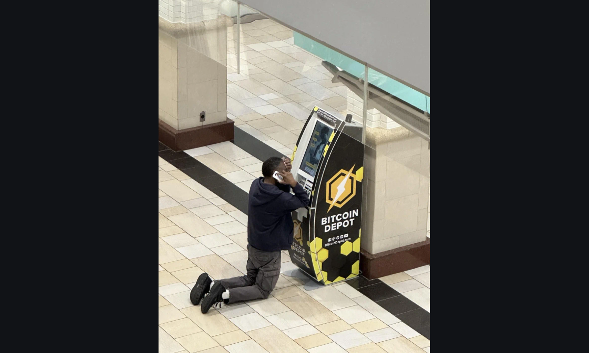 Person using a phone beside a Bitcoin Depot kiosk in an indoor public concourse